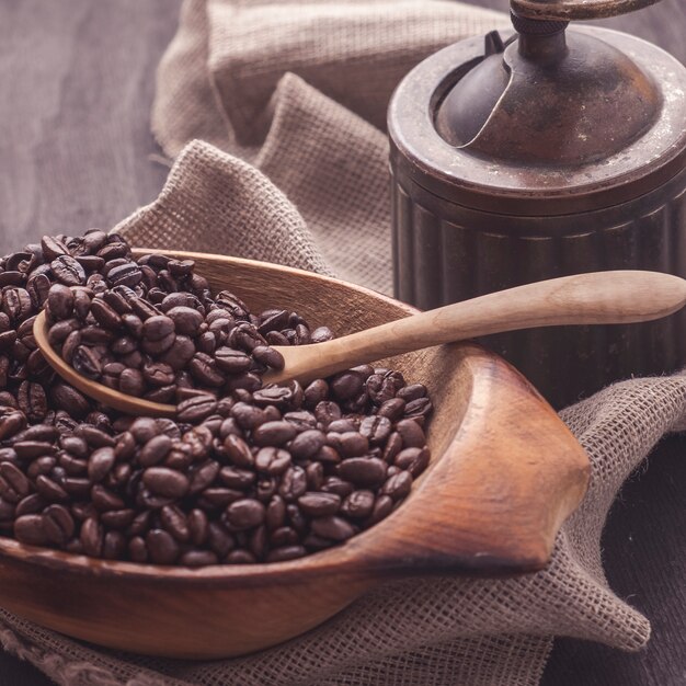 Grains de café torréfiés dans un bol en bois.