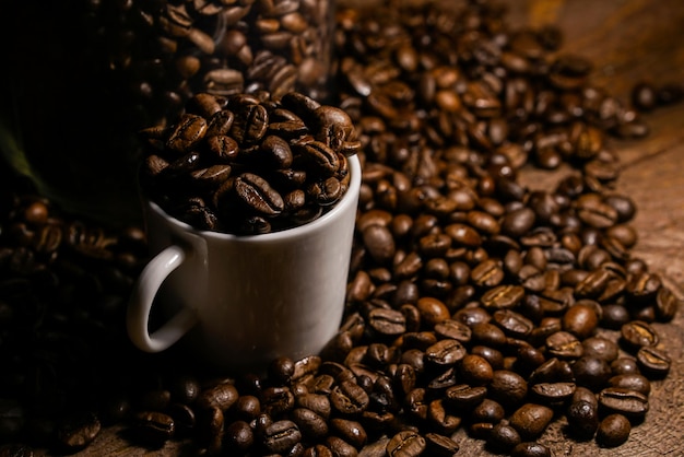 Des grains de café torréfiés dans une tasse sur la table