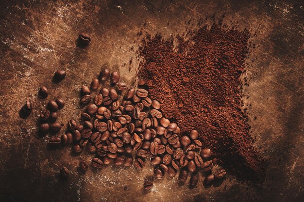 Grains de café torréfiés différents tri moulus et entiers isolés gros plan sur fond grunge marron