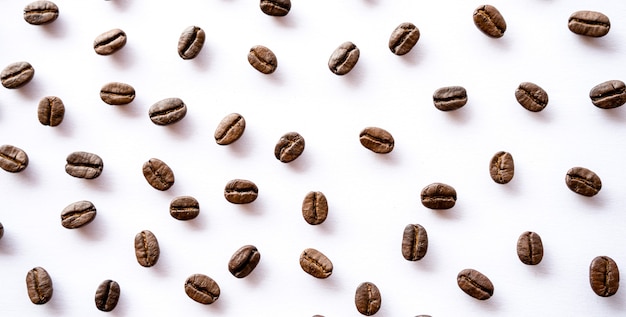 Grains de café torréfiés sur fond blanc