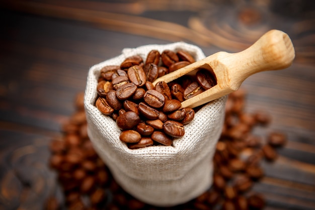 Grains de café torréfiés sur fond de bois