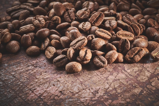 Grains de café torréfiés isolés gros plan sur fond grunge marron