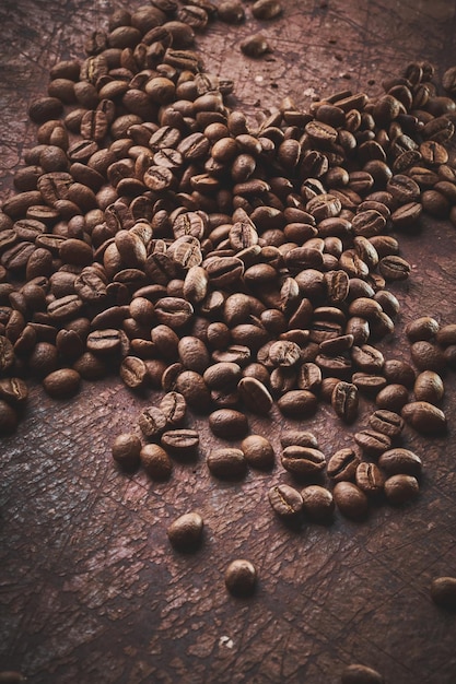 Grains de café torréfiés isolés gros plan sur fond grunge marron