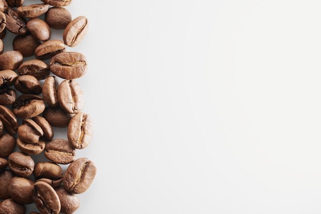 Grains de café torréfiés isolés gros plan sur un tracé de détourage fond blanc