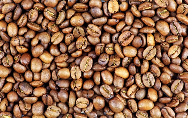 Les grains de café torréfiés peuvent être utilisés comme arrière-plan. Fond de gros plan de grains de café