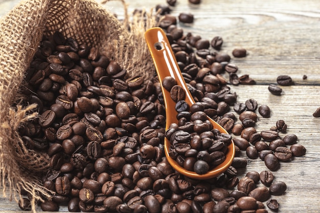 Grains de café torréfiés sur un plancher en bois