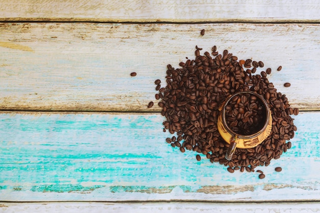 Grains de café torréfiés et une tasse