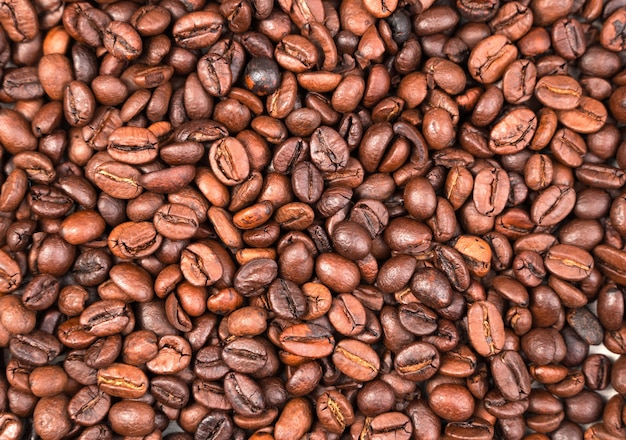 Grains de café torréfiés, vue de dessus, table. Concept de fonds alimentaires.