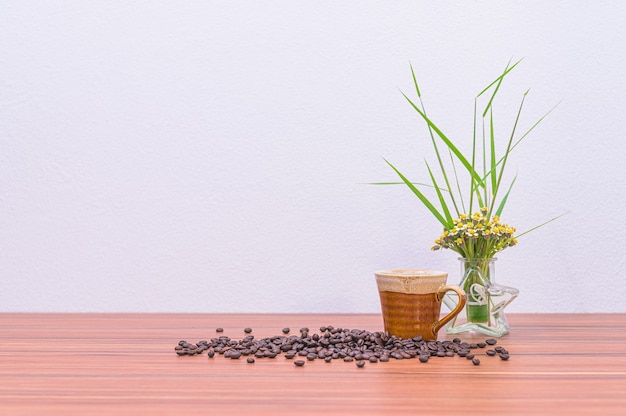 Grains de café et vases à fleurs sur le bureau