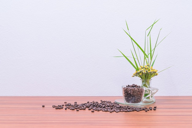 Grains de café et vases à fleurs sur le bureau