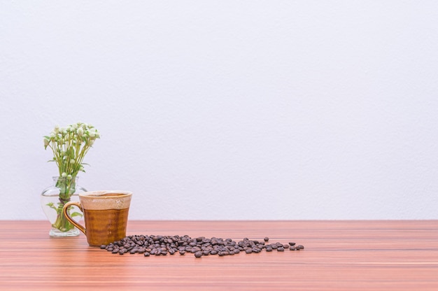 Grains de café et vases à fleurs sur le bureau