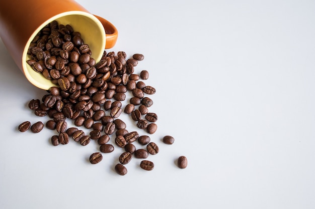 Grains de café en verre brun sur fond de tableau blanc. vue de dessus. espace pour le texte