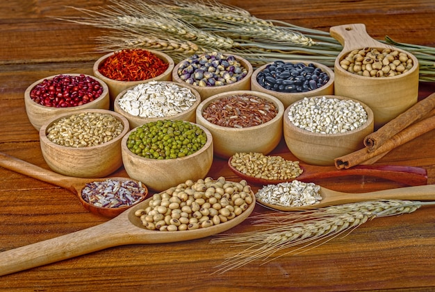 Photo grains de céréales, graines, haricots sur fond de bois.