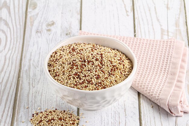 Grains de céréales de quinoa secs et crus dans le bol