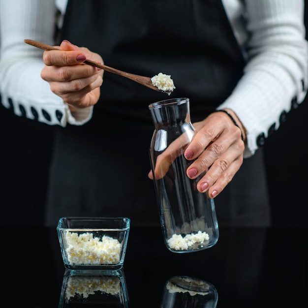 Grains de culture symbiotique mésophile de kéfir sur une cuillère en bois utilisée pour le kéfir fait maison