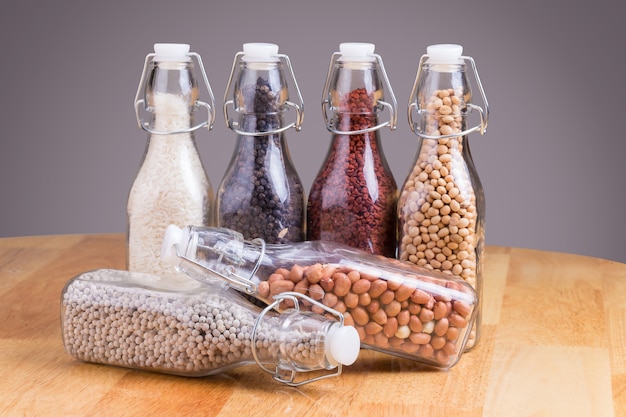 grains dans la bouteille sur fond en bois.