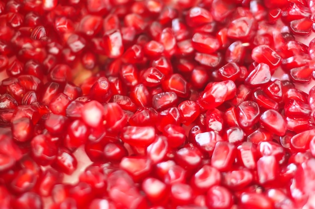 Grains de grenade mûrs rouges sur fond blanc.