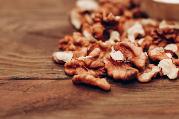 Grains de noix séchés éparpillés sur une table en bois