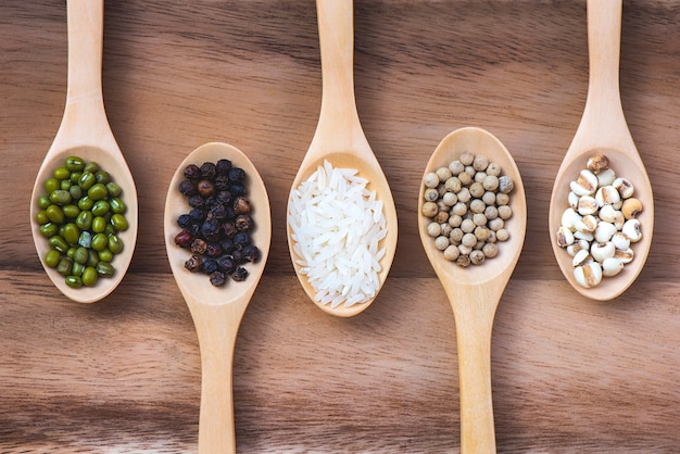 Grains placés sur 5 cuillères placées sur une table en bois