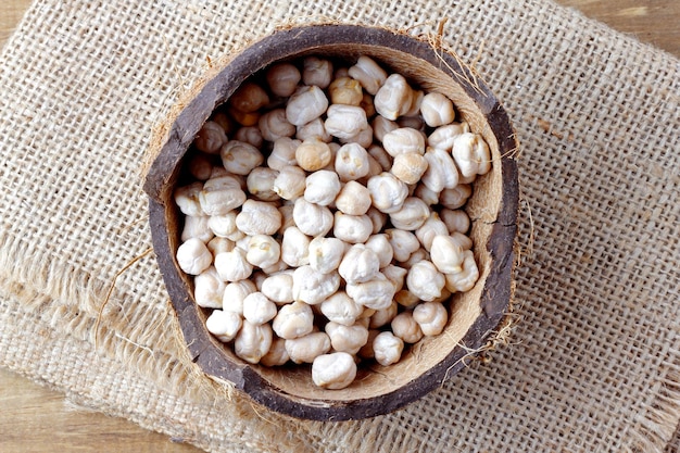 Grains de pois chiches biologiques crus dans un bol sur une table en bois rustique Vue de dessus