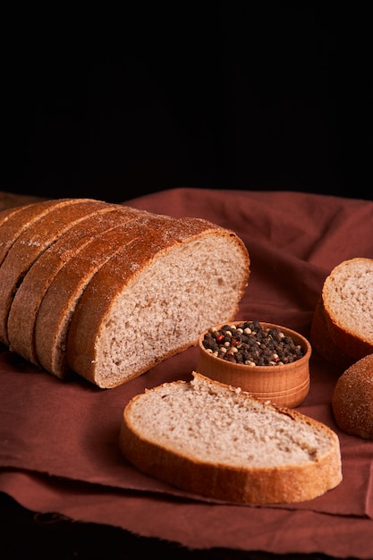 Grains de poivre dans un bol en bois sur une table avec un style rustique