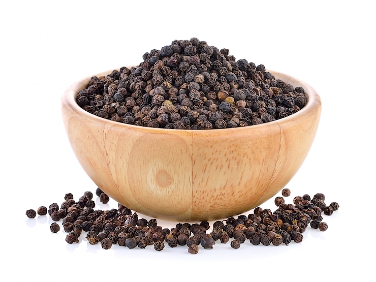 Photo grains de poivre dans un bol en bois