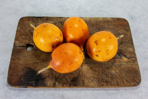 Granadilla quatre fruits péruviens à peau dure sur une assiette en porcelaine et planche de bois