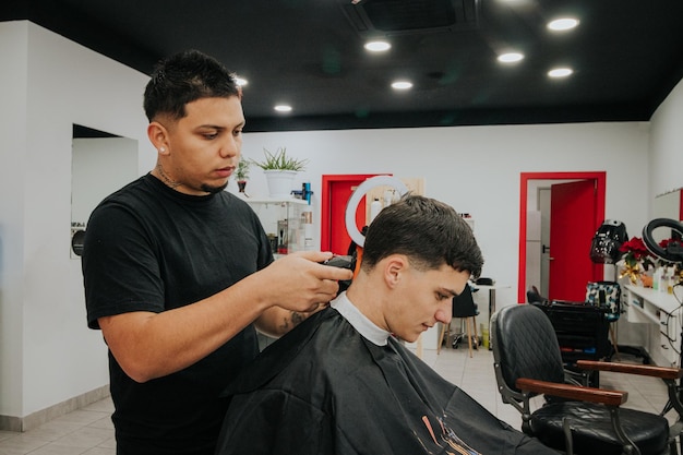 Photo grand angle de coiffeur passant la tondeuse à cheveux au client