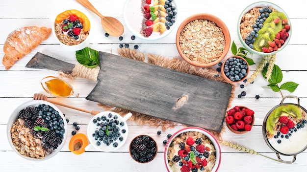 Grand assortiment de bouillie de fruits et de baies Petit-déjeuner Sur un fond en bois blanc Vue de dessus Espace libre pour le texte