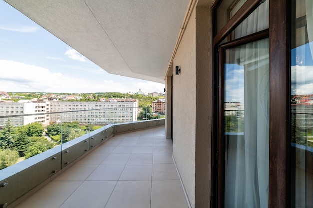 Grand balcon vide propre dans la maison avec de grandes fenêtres