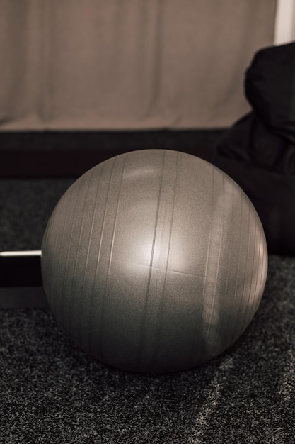 Un grand ballon de fitness gris se trouve dans la salle de sport