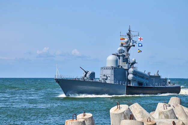 Photo grand bateau lance-missiles lors d'exercices et de défilés navals, destroyer lance-missiles guidé par la marine russe manoeuvrant en mer baltique. navire de guerre militaire moderne naviguant dans une mer bleu vif