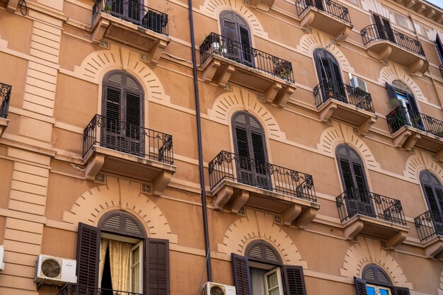 Un grand bâtiment avec des balcons et des stores