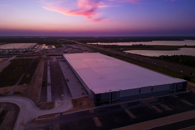 Un grand bâtiment blanc avec un ciel rose au coucher du soleil