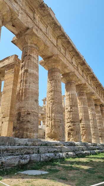 Un grand bâtiment avec des colonnes et un ciel bleu