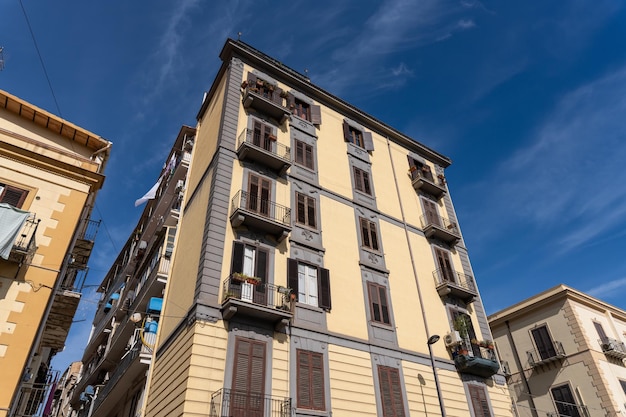 Un grand bâtiment jaune avec des balcons et des fenêtres