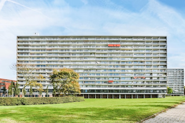 Un grand bâtiment avec une pelouse verte et un trottoir