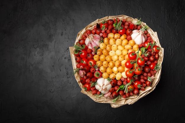 Grand bouquet composé de fromage fumé, de saucisses, de tomate, de poivron et d'ail enveloppé dans du papier kraft