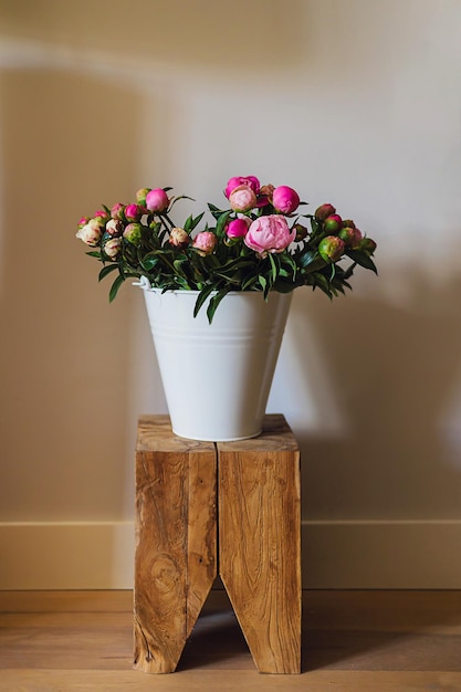 Grand bouquet de fleurs de pivoines roses et blanches fraîches dans un seau en métal blanc sur une table en bois dans un bel appartement moderne et lumineux Décoration de maison de printemps ou idée cadeau Couleurs d'été vives