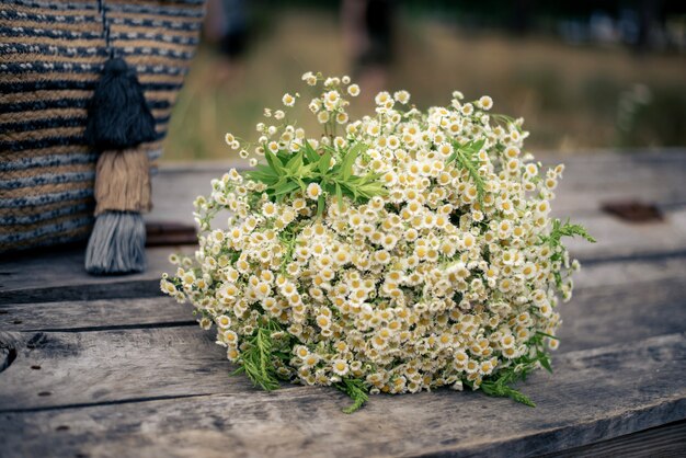 Un grand bouquet de fleurs sauvages avec un sac femelle de paille dans la nature