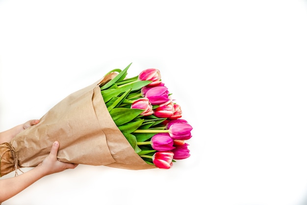 Grand bouquet de tulipes à la main sur un fond blanc en gros plan Concept pour le 8 mars