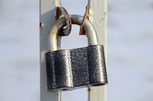 Un grand cadenas gris est suspendu à une porte en métal