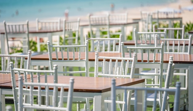 Grand café de plage avec tables et chaises placées au bord de la mer