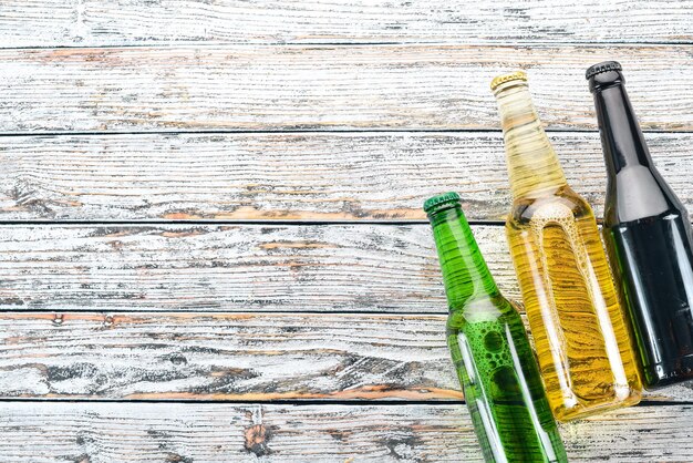 Un grand choix de bouteilles de bière Sur une table en bois blanc Espace libre pour le texte Vue de dessus