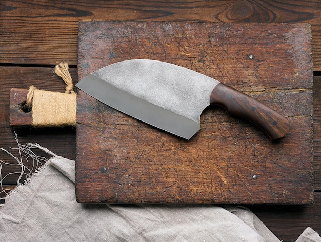 Grand couteau de cuisine sur une vue de dessus de planche à découper en bois vide