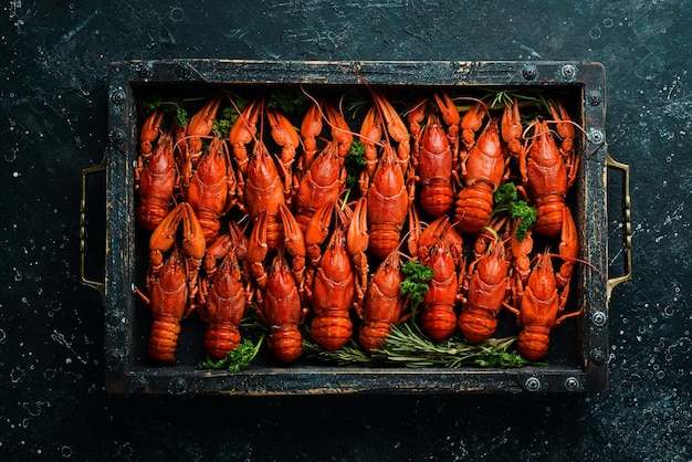 Grand ensemble d'écrevisses rouges dans une boîte en bois Vue de dessus de fruits de mer Mise à plat