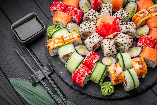 Photo grand ensemble de sushis et de petits pains asiatiques sur fond sombre