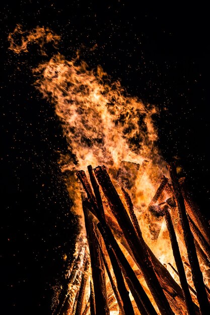 Grand feu de joie la nuit. Flammes de feu sur fond noir