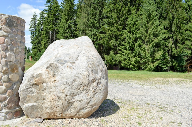 Un grand géant solide gris pavé de pierre naturelle se trouve sur le sol à côté de la colonne