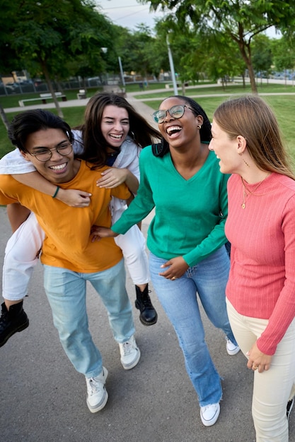 Un grand groupe d'adolescents de différentes races rient et s'amusent à cheval.